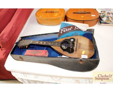 A mandolin in fitted case; and a harmonica 