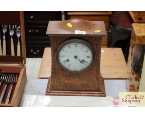 An Arts &amp; Crafts oak inlaid mantel clock