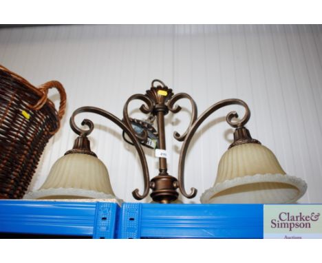 A three branch light fitting with three glass shades