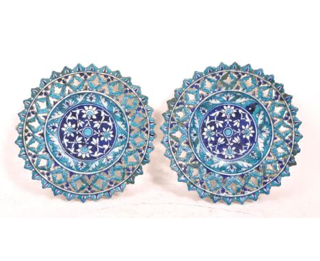 A pair of ceramic earthenware tin glazed Islamic pierced chargers / wall plates in vibrant blue ground with repeated floral g