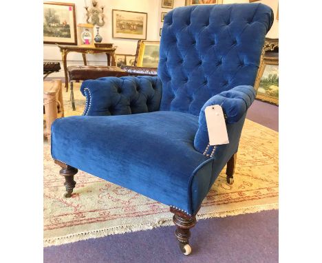 ARMCHAIR, Victorian with deep buttoned blue velvet upholstery on turned supports and ceramic castors, 89cm H x 68cm W x 92cm 