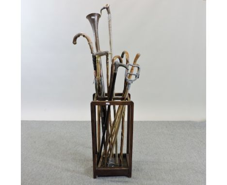 A collection of walking sticks, to include a silver top antler hiking stick, and a hunting horn, together with a stickstand