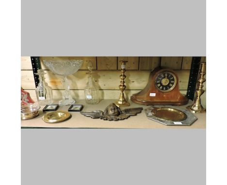 An early 20th century mantel clock, a carving, a pair of brass candlesticks, brass dishes, two decanters and a glass centrepi