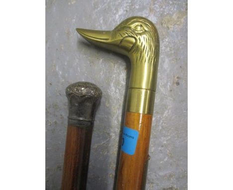 A silver topped walking cane and a reproduction walking stick, the handle in the form of a ducks head 