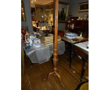 A carved wooden floor lamp base, the stem reeded and carved with leaves and flowers, on a tripod base