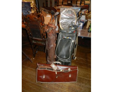 An early 20th century leather golf caddy together with a collection of hickory shafted golf clubs, one other caddy, and sundr
