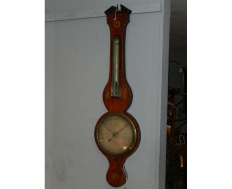 A late George III mahogany wheel barometer, having a broken pediment above floral and shell marquetry paterae, fitted silvere