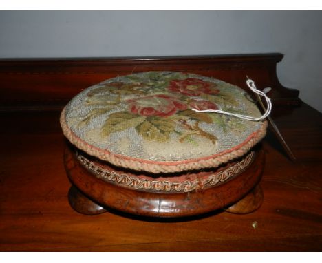A 19th century French walnut circular foot stool, having a foliate wool and beadwork upholstered top, raised on toupee feet.