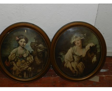 A pair of oval giltwood picture frames, inset polychromatic portrait prints.