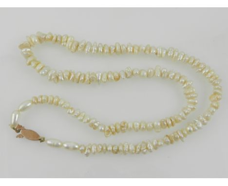 A pearl necklace with yellow metal clasp. 