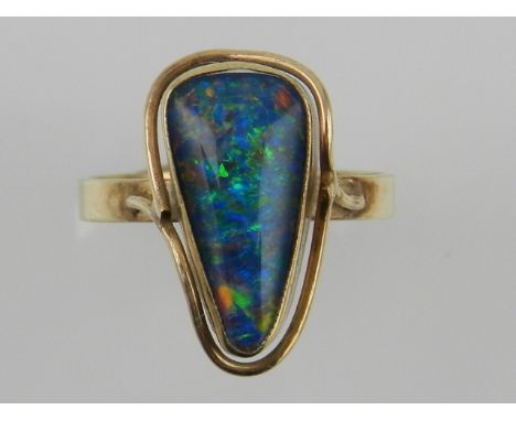 A 9ct yellow gold ring, set with an opal of irregular shape. 