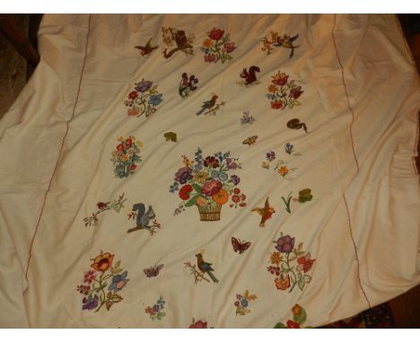 A hand embroidered bed spread, decorated with exotic birds and flowers.