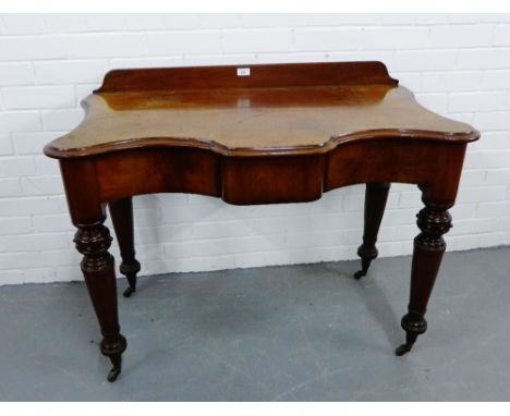 A 19th century mahogany ledgeback side table, the serpentine top over a central frieze drawer raised on turned supports with 