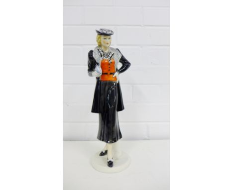 An A.W. Goebel Art Deco figure of a lady, the standing figure dressed in black skirt suit with chequered bow tie and clutch b