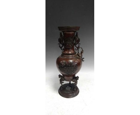 A bronze Japanese two handled vase, Meiji period, with magnolia branch vignettes to the body, and applied dragon handles in r