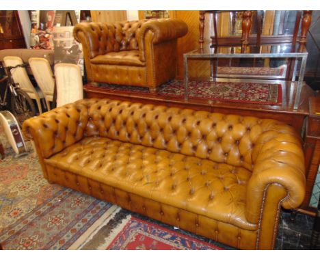 A Chesterfield three seater leather sofa and chair, damage to sofa