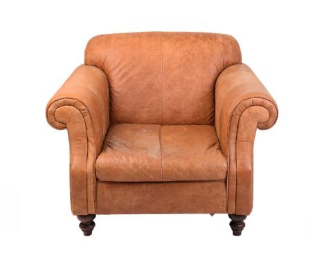 An Edwardian-style distressed tan hide oversized club armchair, twentieth century, with roll-over arms and square back on tur