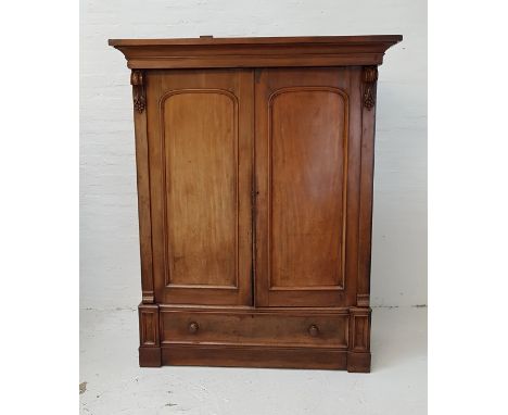 VICTORIAN MAHOGANY WARDROBEwith a moulded cornice above a pair of arched panelled doors flanked by carved scrolls, the interi