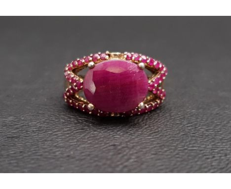 RUBY DRESS RINGthe central oval cut ruby surrounded by smaller rubies to the pierced setting, in silver gilt, ring size L-M 