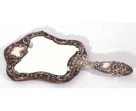 Late Victorian silver mounted dressing table hand mirror, the bevelled mirror surrounded by foliate silver mounts and a silve