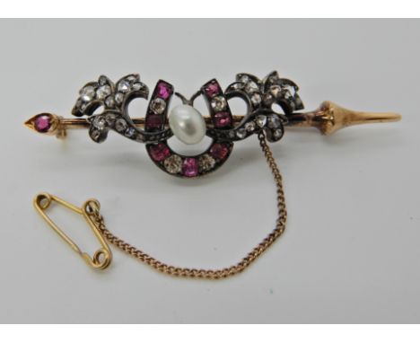 A YELLOW AND WHITE METAL DIAMOND AND RUBY HORSESHOE BROOCH set with both old cut and rose cut diamonds. Dimensions 5.9cm x 1.