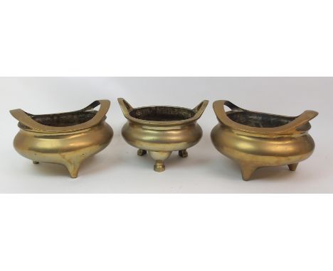 A CHINESE BRASS TWO-HANDLED CENSER on tripod base, cast six character mark, 15cm high x 23cm diameter, another 16cm high x 23