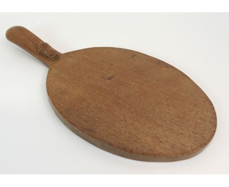 A ROBERT 'MOUSEMAN' THOMPSON OF KILBURN OAK CHEESE BOARD of oval form, the handle carved with a mouse motif, 38cm long Condit