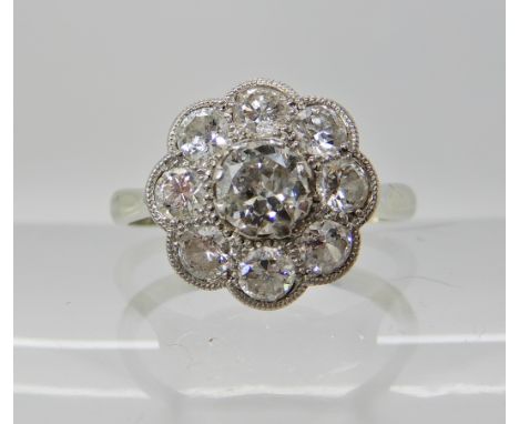 AN 18CT WHITE GOLD DIAMOND FLOWER RING the central diamond is estimated approx 0.30cts and surrounded with further diamonds i