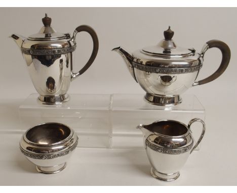 A FOUR PIECE SILVER TEA SERVICE by Walker & Wheeler, London 1959, of tapering cylindrical shape with a band of Celtic decorat