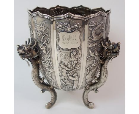 A CHINESE SILVER PRESENTATION LOBED VASE decorated with panels of figures, dragons, birds and foliage, with shield medallion 