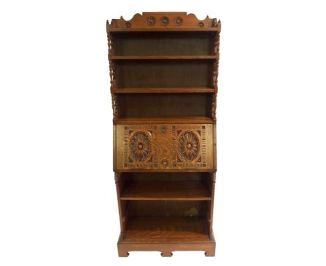 A VICTORIAN OAK BUREAU BOOKCASE with three open shelves above a carved fall flap enclosing pigeon holes above an open shelf a