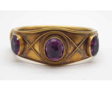 A BRIGHT YELLOW METAL AMETHYST SET VINTAGE BANGLE the amethysts are in foiled closed back settings, some set pavilion out, wi
