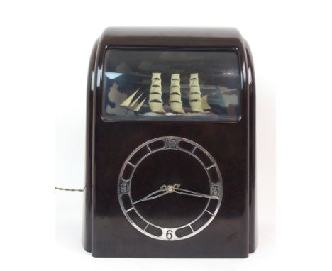 A VITASCOPE INDUSTRIES LTD BAKELITE CASED ELECTRIC SHIP AUTOMATA CLOCK the brown case with a curved front and glazed seascape