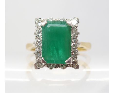 AN 18CT GOLD EMERALD AND DIAMOND RING set with estimated approx 0.50cts of brilliant cut diamonds, the step cut emerald is ap