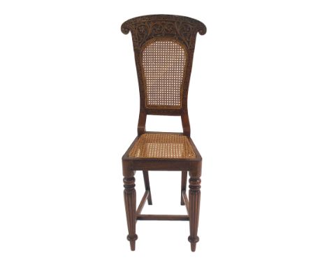 AN ANGLO INDIAN ROSEWOOD HIGH CHAIR the back rest carved with scrolling foliage surrounding a cane back and seat above ring t