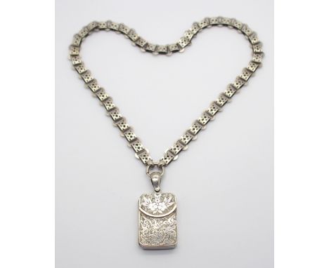 A VICTORIAN WHITE METAL LOCKET AND CHAIN with star detailed chain and the locket in the shape of a purse with floral engravin