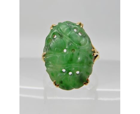 A BRIGHT YELLOW METAL CHINESE GREEN HARDSTONE RING carved with fruit. Dimensions of the hardstone 17.5mm x 12.3mm. Finger siz