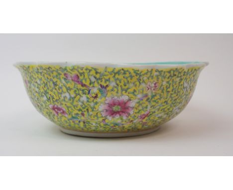 A CHINESE YELLOW GROUND FRILLED BOWL exterior with peonies and scrolling foliage, Qianlong seal mark but later (some enamel w