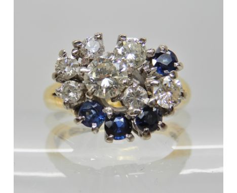 AN 18CT GOLD DIAMOND AND SAPPHIRE RETRO CLUSTER RING largest diamond is estimated approx 0.25cts with further diamonds taking