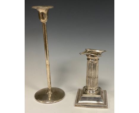 A silver candlestick, fluted column, weighted base, Birmingham 1902, 11.53ozt gross;  an Arts and Crafts style elongated cand