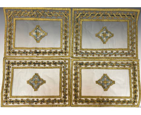 A set of four 19th century embroidered table mat tapestry panels, central medallions within floral surrounds, in pale blue/gr