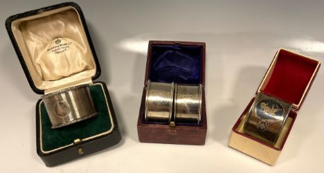 A pair of silver napkin rings, E Edmonds, Birmingham 1917, cased;  another wavy banded, Mappin &amp; Webb ,Birmingham 1939, 4