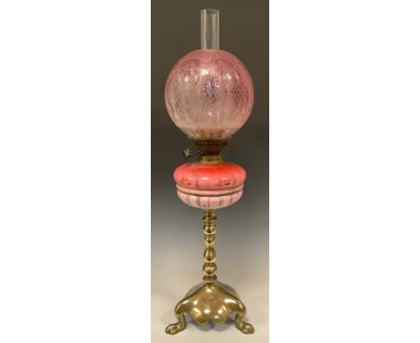 A Victorian oil lamp, etched cranberry glass globe shade, opaque cranberry glass reservoir with painted decoration, brass lio