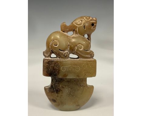 A Chinese carved stone tablet/pendant possibly Hetian Jade, as a foe dog seated above axe head terminal, 7.4cm x 3.8cm 