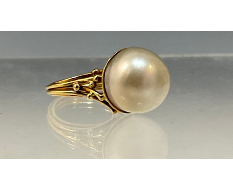 A large cultured pearl ring, creamy grey pearl approx 13mm diameter, unmarked yellow metal shank, size O, 9.3g gross 
