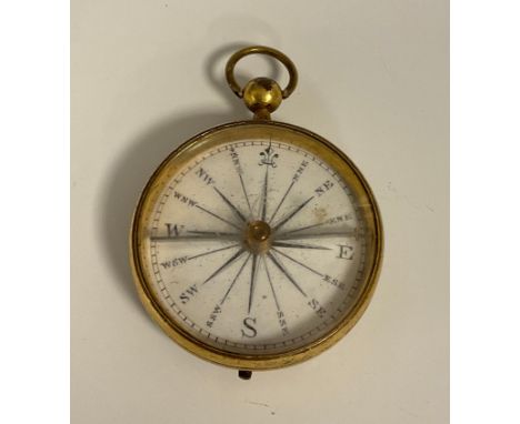 A Georgian gilt cased compass, white dial, black sixteen point scale, locking slide gilt case, 4cm diameter. 