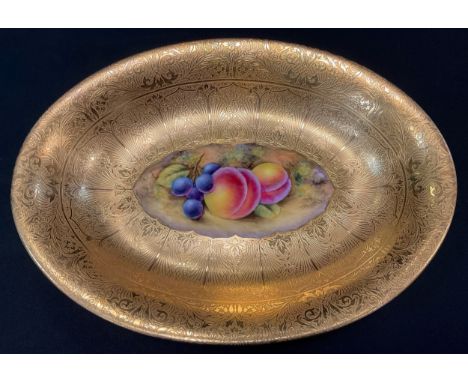 A Royal Worcester oval dish, decorated by J Smith, signed, painted with ripe fruit on a mossy bank to centre, broad gilded bo