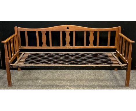 An Arts and Crafts oak sofa / day bed, serpentine shaped back, baluster-shaped splats, the back with lift-and-release mechani