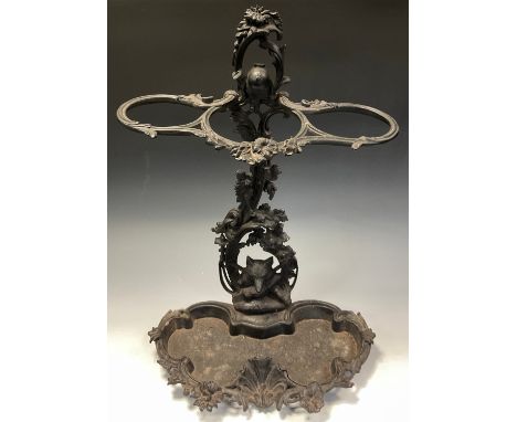 A cast iron stick/umbrella stand cast as jockeys hat within floral foliate column, fox head and crossed boots base, serpentin