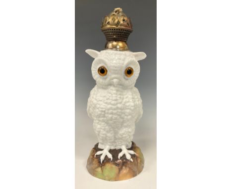 A 19th century continental porcelain oil lamp, as a standing Owl, with bulbous glass eyes, white body, stood on a naturalisti